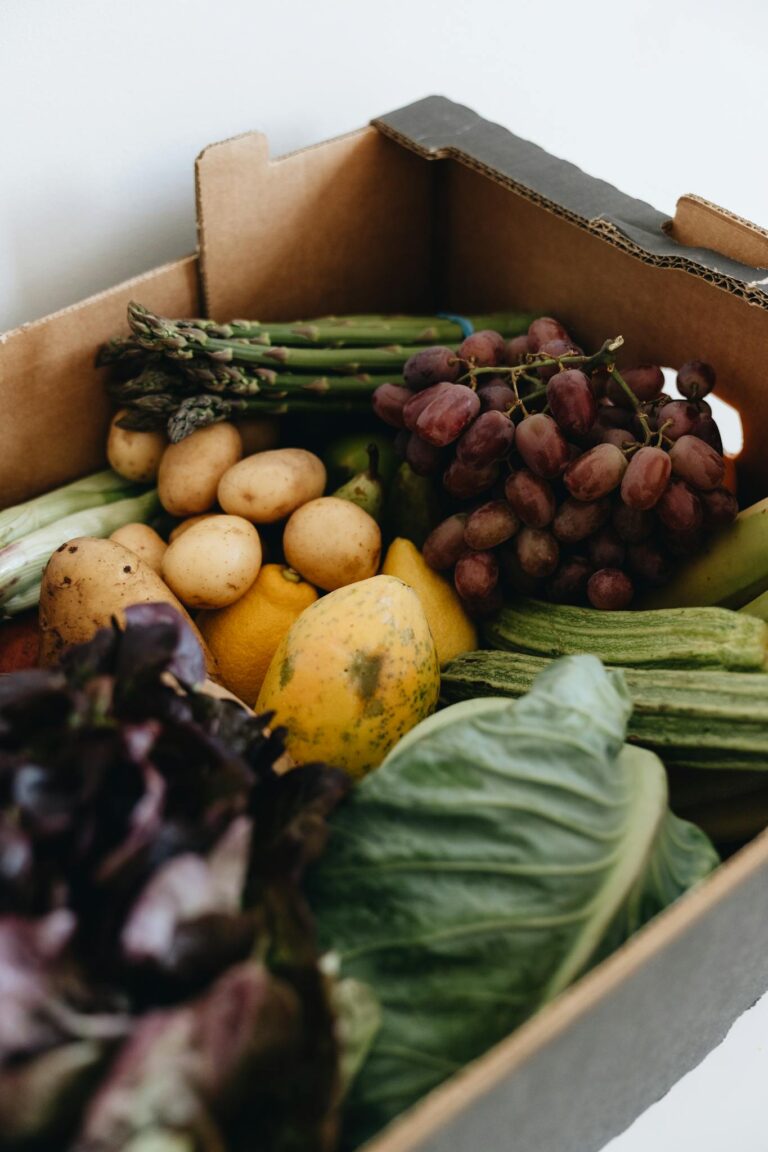 Close-up of a cardboard box filled with fresh vegetables and fruits, perfect for healthy living.